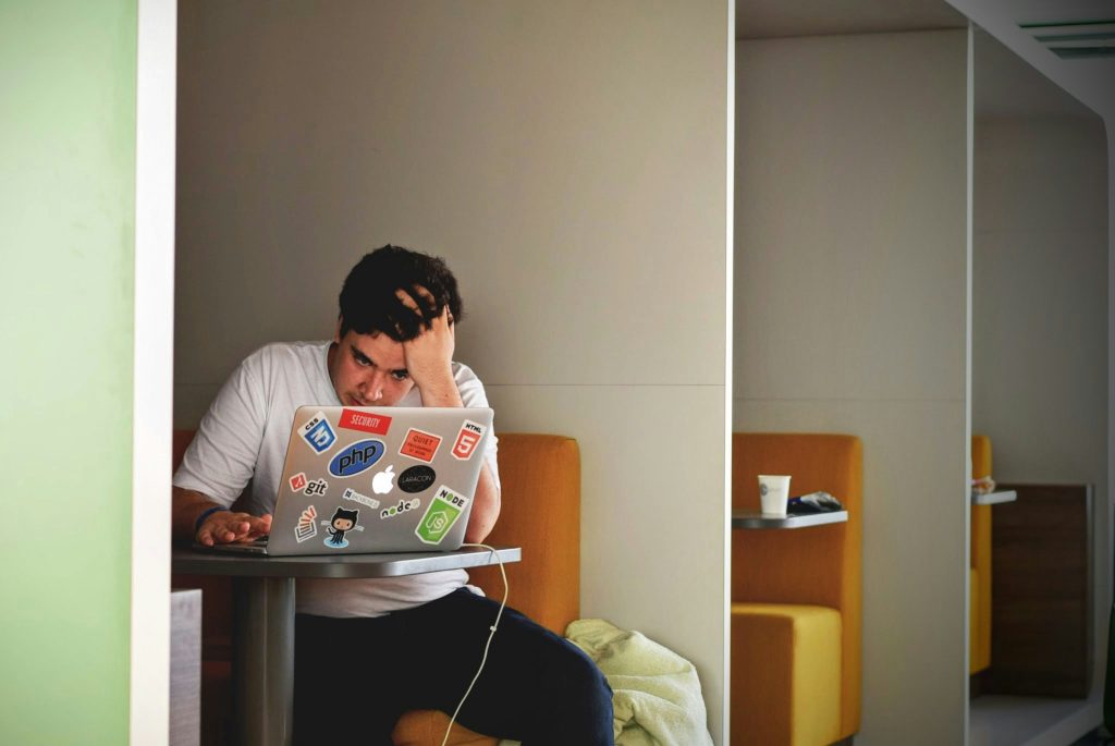 Man sitting at a laptop with his head in his hands because ChatGPT isn't showing his website in results