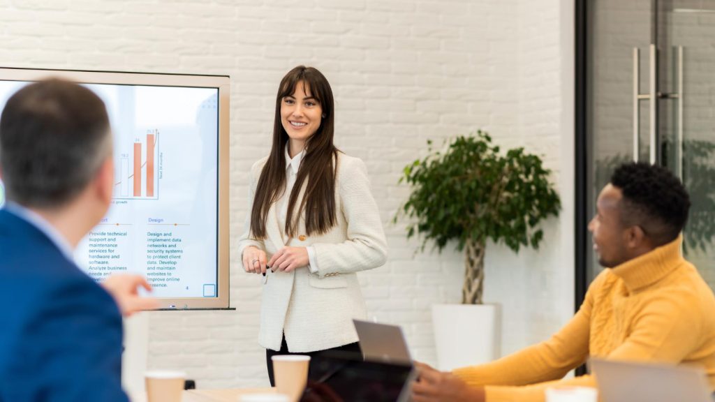 Woman in white jacket giving a presentation using Annual General Meeting software