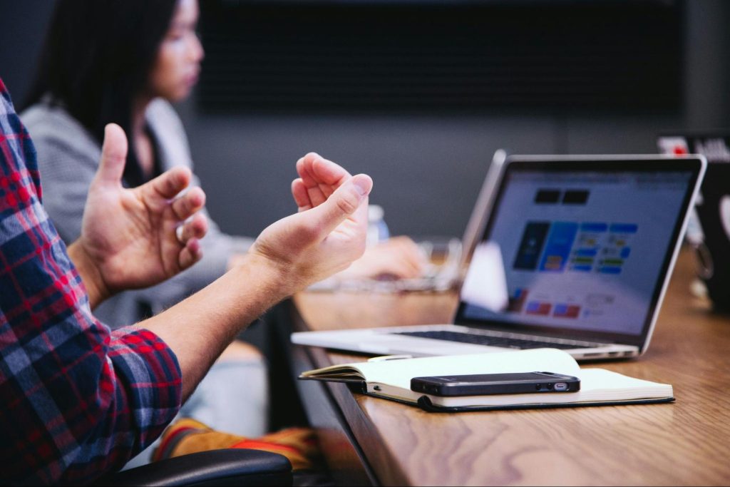 Close up of a meeting agenda on a laptop screen with a man's hands in frame