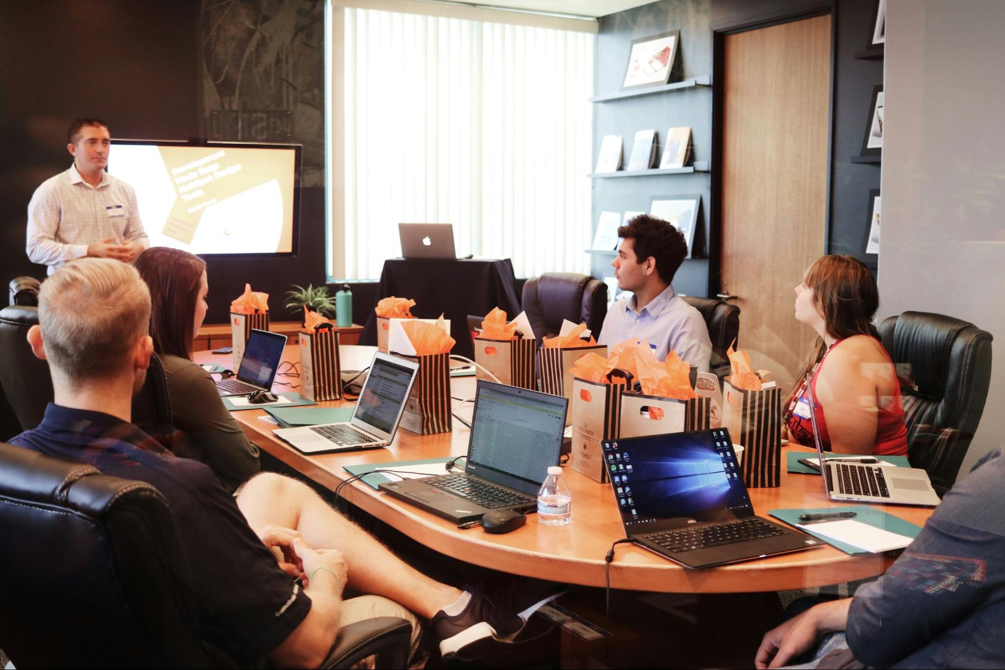 Productive meeting agenda - a group of people in a meeting looking at the speaker