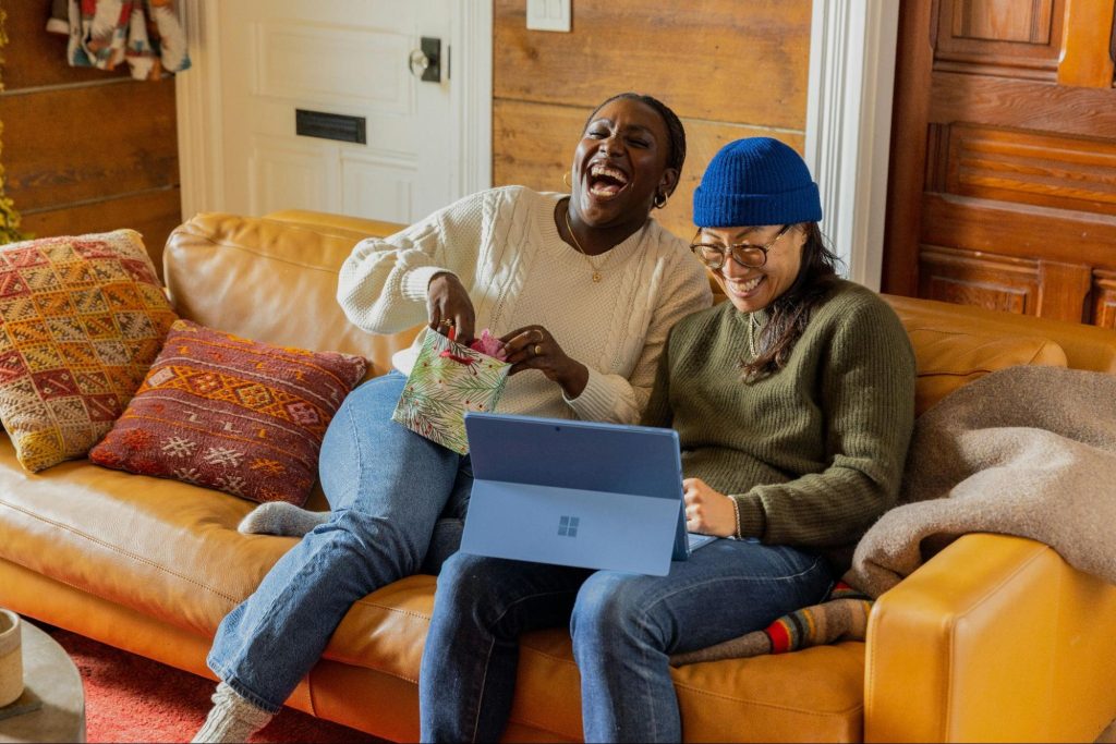 Colleagues laughing looking at a laptop